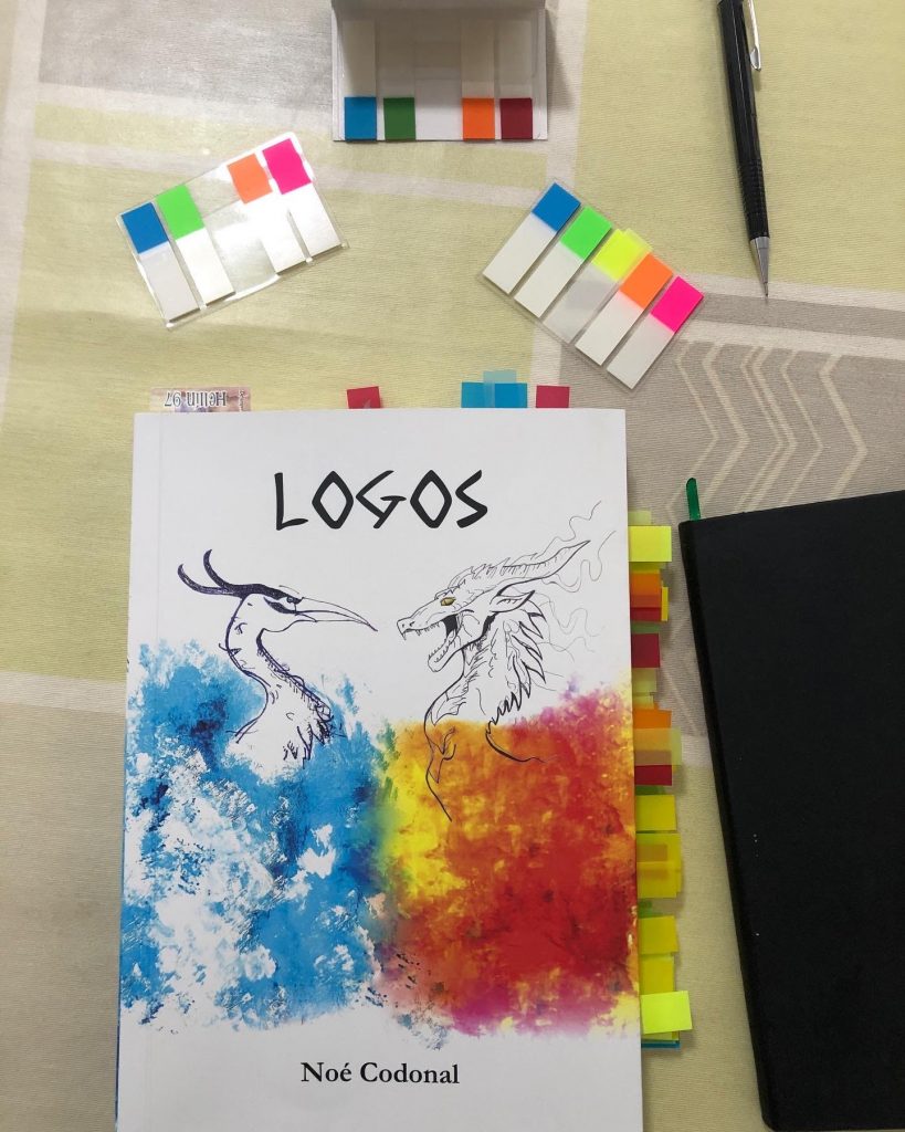 Libro "Logos", con etiquetas de colores pegadas marcando las correcciones que debemos hacer.